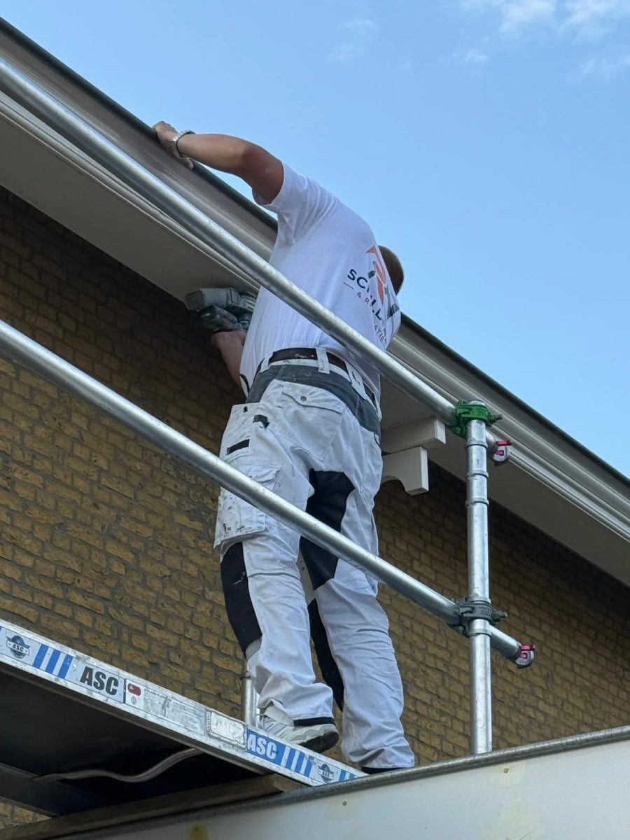 Schilder van RN Schilders aan het werk op steiger